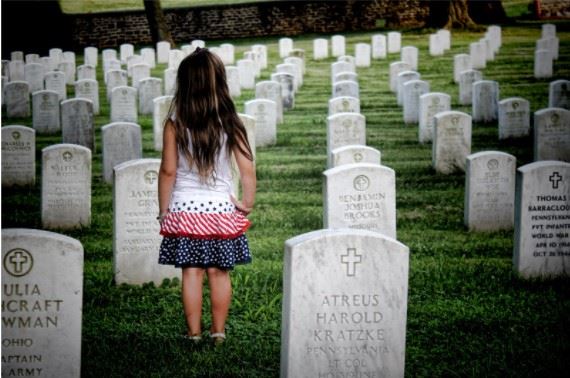 little girl standing at the graveside of a deceased loved one
