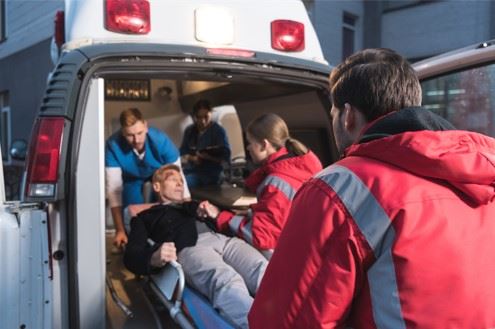 man being loaded into ambulance after serious accident