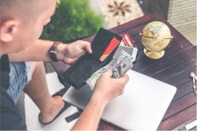 man counting out money from wallet