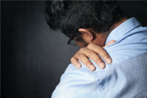 man holding his injured shoulder after an accident