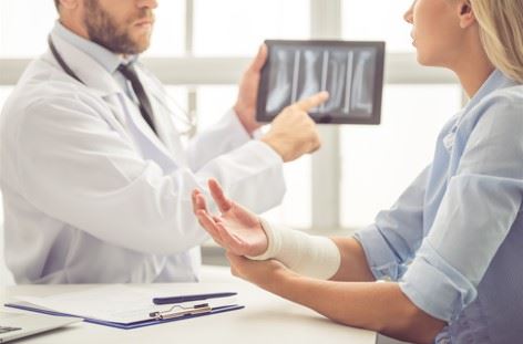 woman with broken arm talking to doctor