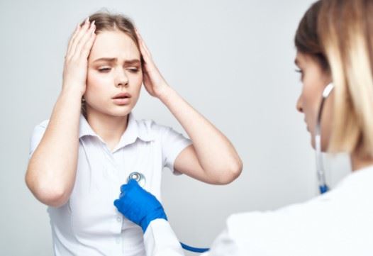 young woman holding her head after an accident