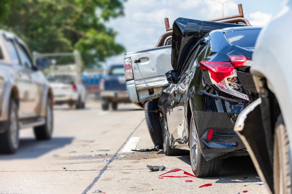 Vehicles with visible rear-end damage after a car accident on the road