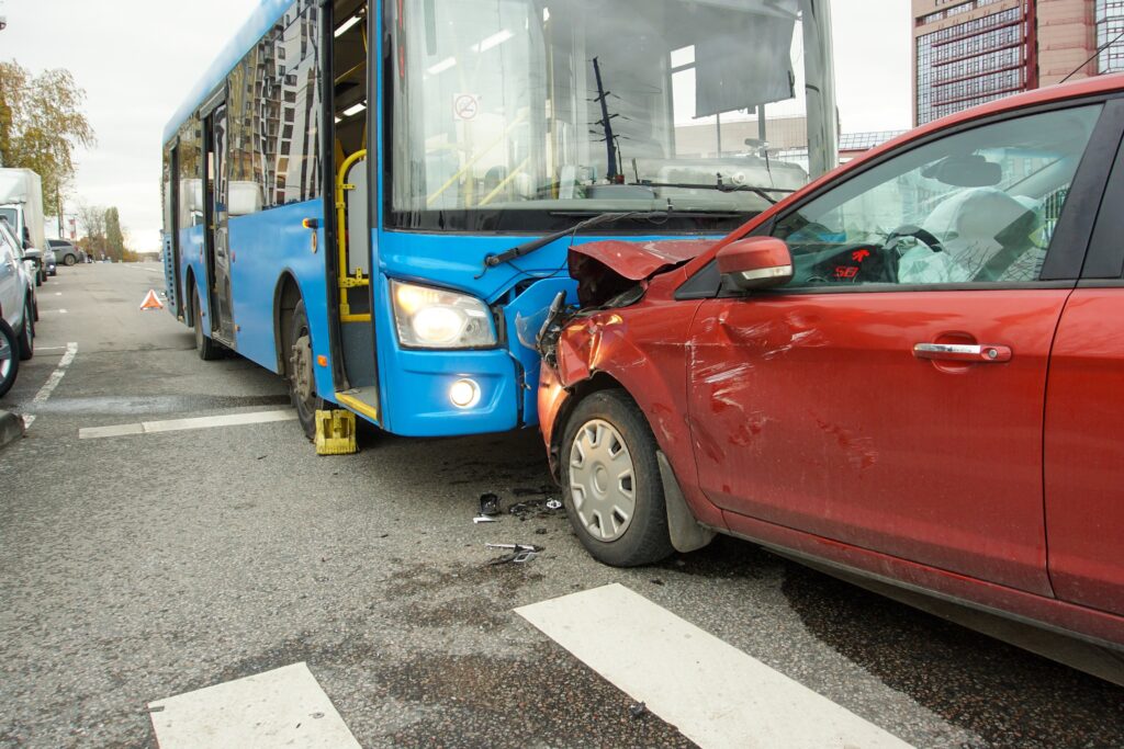 Bus involved in a crash with a red car